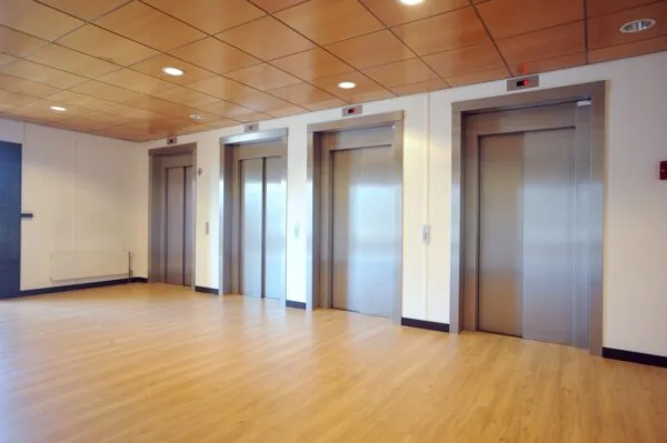 Hal met vier gesloten liften in een modern kantoorgebouw aan het Rivium Boulevard.